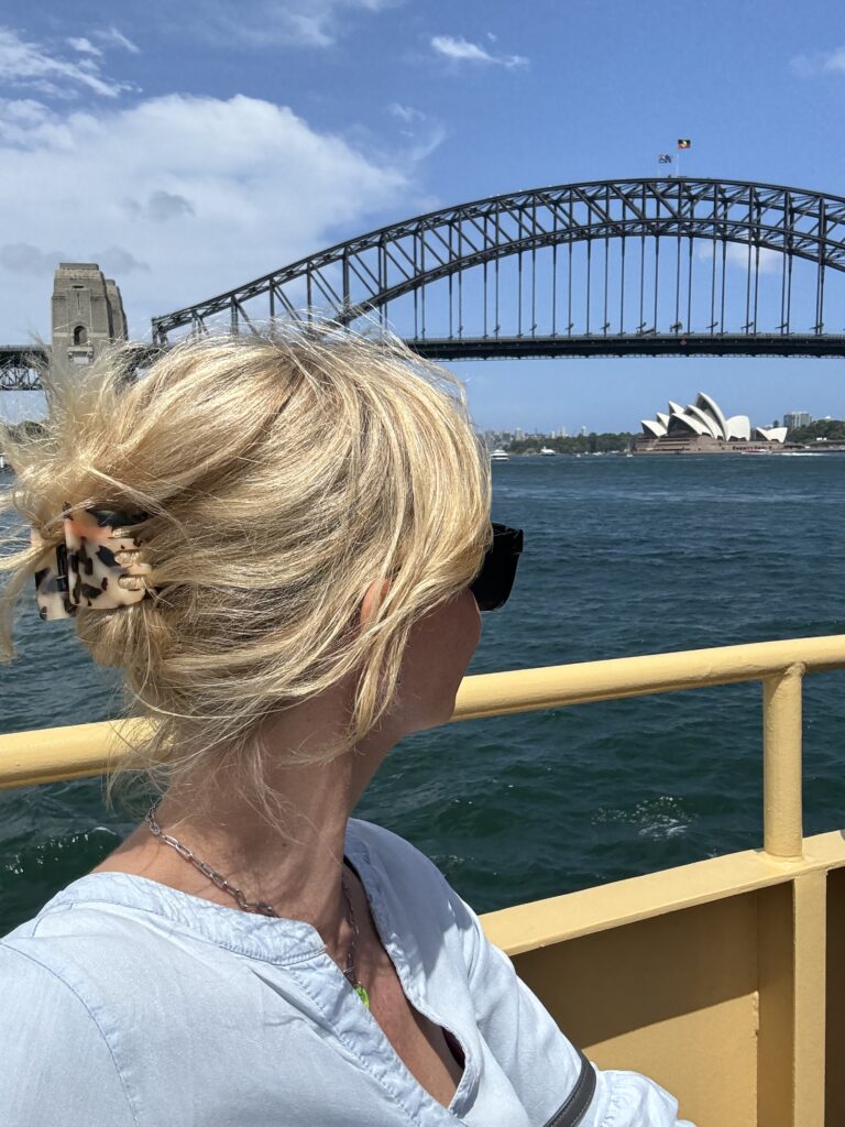 Jenny Heyer blickt über das Wasser auf die Sydney Harbour Bridge und das Opernhaus.